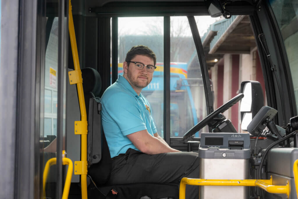 photo of Matthew Rosenbloom-Jones in drivers seat of a TCAT bus